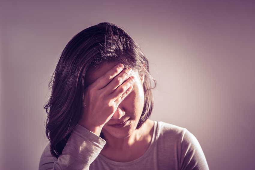 young woman with her head in her hand, sad, depressed, substance use disorder