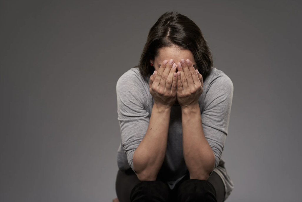 A person covering their face with their hands.