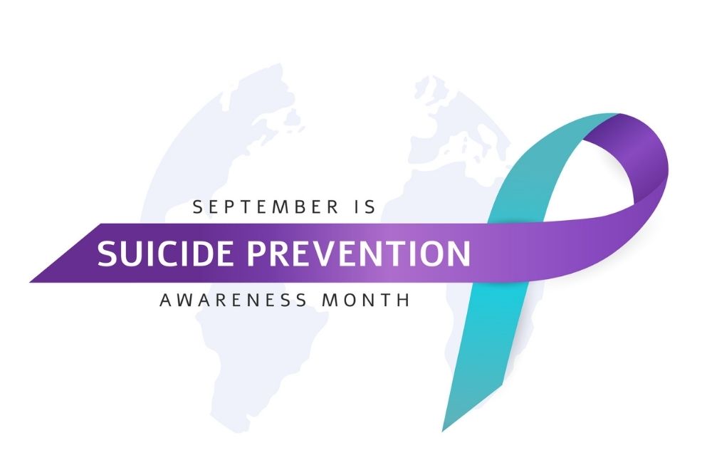 Purple and teal ribbon with text reading ‘September is Suicide Prevention Awareness Month.’